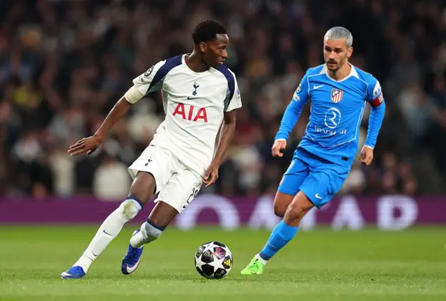 Pape Matar Sarr (Tottenham) court avec le ballon sous la pression d'Antoine Griezmann (Atlético de Madrid) lors du match retour des huitièmes de finale de l'UEFA Champions League 2025/26.