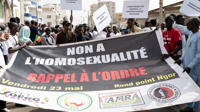 Des manifestants brandissent une pancarte sur laquelle on peut lire 'non à l’homosexualité' lors d’une manifestation réclamant la criminalisation de l’homosexualité au Sénégal, à Dakar, le 23 mai 2025