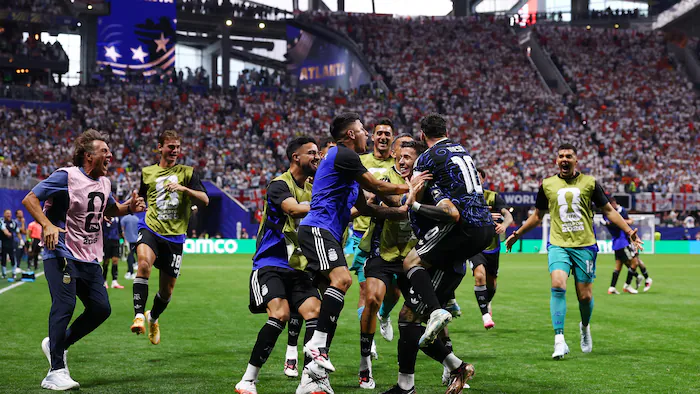 Des joueurs de soccer se regroupent pour célébrer un but marqué en fin de match.