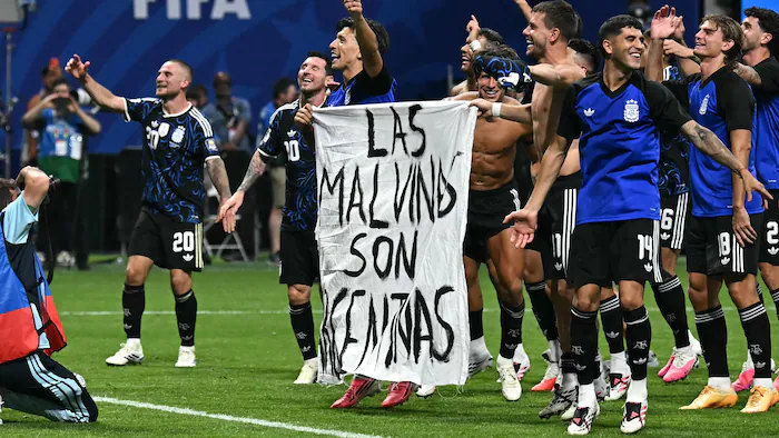 Des joueurs argentins brandissent une banderole avec l'inscription 'les Malouines sont argentines'.