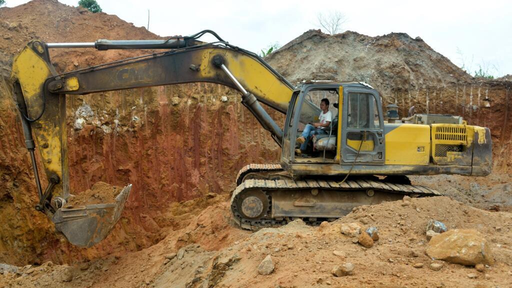 Un employé chinois d'une société minière conduit un bulldozer sur un site minier de la ville de Betare Oya, au Cameroun, le 4 avril 2018.